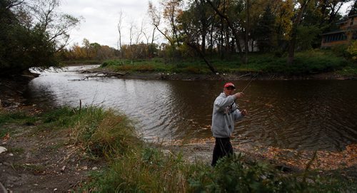 Mike Horbow tends his fishing line on Sturgeon Creek near it's mouth at the Assinaboine River. September 30, 2015 - (PHIL HOSSACK / WINNIPEG FREE PRESS)