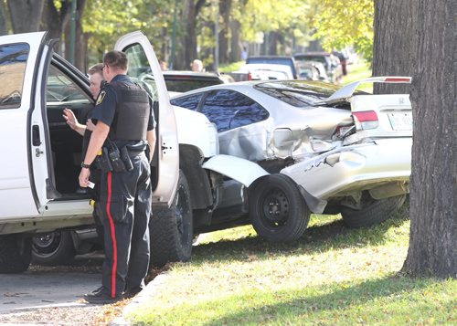 Winnipeg Police investigate inside a truck they were perusing that crashed into a parked car on Lipton St just south of NotreDame Ave Thursday afternoon-It is unknown if arrests were made or if there were injuries- Canine unit arrived at scene- Breaking News- Sept 30, 2015   (JOE BRYKSA / WINNIPEG FREE PRESS)