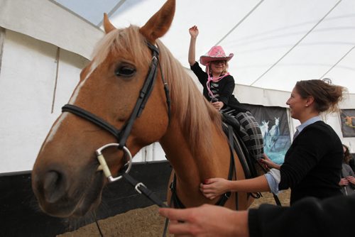 Seven-year-old Claire raises one hand in the air while getting ready to ride a horse  while visiting Odysseos equestrian world with other CHILDREN FROM THE CANADIAN NATIONAL INSTITUTE FOR THE BLIND on Thursday afternoon.   See story.   Oct 01, 2015 Ruth Bonneville / Winnipeg Free Press