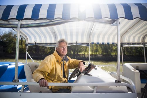 Gord Cartwright, owner of owner of Splash Dash water tours and taxis, sits in the captain seat of one of his boats at The Forks for the Rivers Project in Winnipeg on Friday, Oct. 2, 2015.  (Mikaela MacKenzie/Winnipeg Free Press)