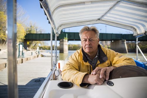 Gord Cartwright, owner of owner of Splash Dash water tours and taxis, sits in the captain seat of one of his boats at The Forks for the Rivers Project in Winnipeg on Friday, Oct. 2, 2015.  (Mikaela MacKenzie/Winnipeg Free Press)