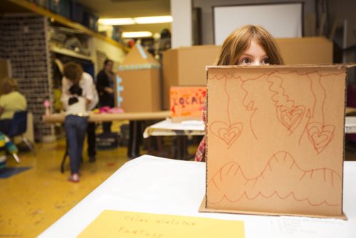 Gwyn Lewis, 7, peeks out from a fancifully decorated ballot box at the Kids Can Vote election, which includes categories like Winnipeg's best pizza and sport teams as well as federal candidates, at Art City in Winnipeg on Friday, Oct. 2, 2015.  (Mikaela MacKenzie/Winnipeg Free Press)