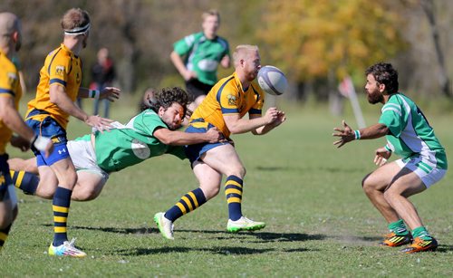 A member of the Winnipeg Saracens, middle, passes the ball before he was wrapped up by a member of the Wanderers during their finals game at Maple Grove Rugby Park, Saturday, October 3, 2015. (TREVOR HAGAN/WINNIPEG FREE PRESS)