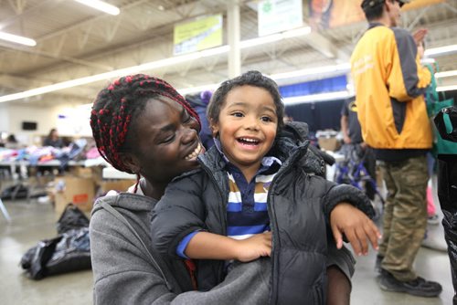 Three-year-old Dennis Kargbo-Smith gets a warm embrace from his mom, Edith, after trying on a winter coat and finding one that fit him at the second annual Wpg Street Store held at the Indian and Metis Friendship Centre Saturday.  The pop-up store that is specifically designed for individuals with low  or no income offering them free clothing and hygiene items was expanded to include bicycle repairs and haircuts.  Standup photo   Oct 03, 2015 Ruth Bonneville / Winnipeg Free Press