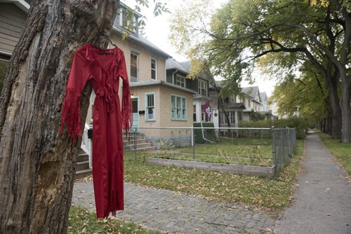 DAVID LIPNOWSKI / WINNIPEG FREE PRESS 151004  Red dresses hang in the Wolseley area as seen Sunday October 4, 2015. Artist Jaime Black has a callout for women to wear red dresses today, or hang them outside their houses as part of her MMIW redress project.