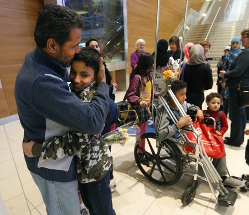 Young Mohammed Abdullah hugs his uncle Kamal who was one of the 24 Syrians that arrived at James A Richardson International Airport Monday afternoon and were greeted by family and volunteers. At right in the wheel chair is Mohammed's cousin Omar,14. The refugees have been living in a refugee camp for more than a year and were privately sponsored to come to Canada.  Carol Sanders story  Wayne Glowacki / Winnipeg Free Press October 5 201