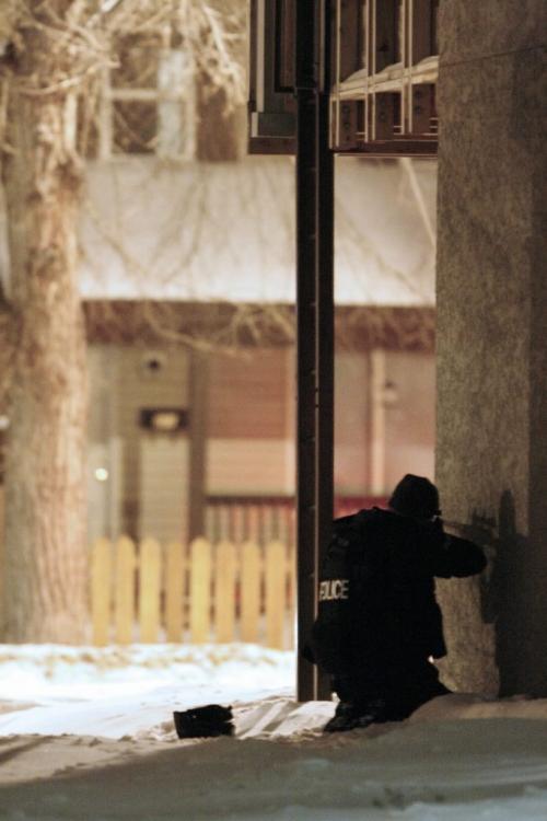 John Woods / Winnipeg Free Press / January 4, 2008- 080104  - An ERU officer trains their rifle on  371 Maryland.  Winnipeg police surround 371 Maryland after a body was found in the backyard of the home Friday, January 4, 2008.