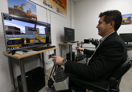 Paul Holden, pres. and CEO of the Manitoba Institute of Trades and Technology tries out their new excavator simulator in the heavy equipment classroom.  Martin Cash story Wayne Glowacki / Winnipeg Free Press October 8 2015