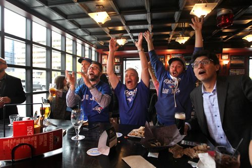 Toronto Blue Jays baseball fans celebrate after the Jays got a run in the 6th inning as they watch the game against Texas on TV at the Pint Thursday afternoon.   Names from left - Ross McFadyen (hat, suit jacket), Scott Hoeppner (glasses, jersey), Glen Agar (white hair, centre), Chris Stanton (hat, jersey, cape) and Sacha Paul (suit, far right). Oct 08, 2015 Ruth Bonneville / Winnipeg Free Press