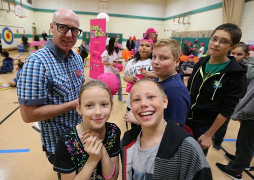 Virgin 103.1 FM radio host Ace Burpee signs caps and posters for students at Ralph Brown School during the launch of the fourth annual Winnipeg Police Association Cool 2Be Kind anti-bullying campaign. The students were, front, L-R, Isaiah Bergeron (Grade 5) and Natalia Sanderson (Grade 4) and rear, L-R, Keiran Spence (Grade 6) Devid Beilis (Grade 6), Xavier Buternowsky (Grade 8). Photo by Jason Halstead/Winnipeg Free Press RE: Standup photo