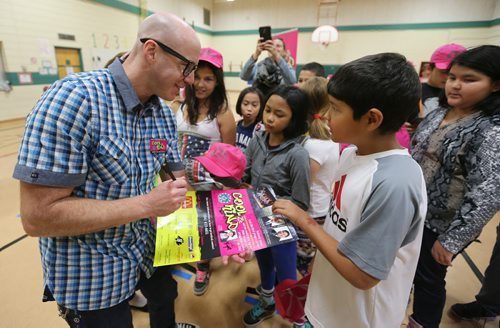 Virgin 103.1 FM radio host Ace Burpee signs a poster for Grade 5 student Jayden Hunter-Park at Ralph Brown School during the launch of the fourth annual Winnipeg Police Association Cool 2Be Kind anti-bullying campaign. Photo by Jason Halstead/Winnipeg Free Press RE: Standup photo
