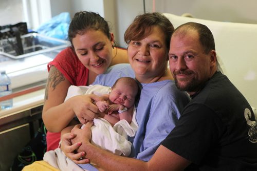 7-hour-old, Savannah Florence Owczar rests peacefully in her mother, Deborah Owczar's arms with her dad, Kristian and her older sister,  Stephanie Jebb, next to her at St. Boniface Hospital Friday morning.  The little girl was born in the passenger seat of the families truck on Sturgeon Rd. @ Silver at 5:25am this morning  on their way to St. Boniface Hospital.   See Story    Oct 09, 2015 Ruth Bonneville / Winnipeg Free Press