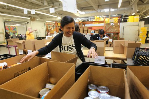 Rina Salazar helps sort food items that are being packaged up for Thanksgiving hampers at Winnipeg Harvest Saturday afternoon.  Her family of four, husband and two sons, immigrated to Canada in June as landed immigrants and wanted to give back to the community that has helped them settle into a new country they now call home. See Carol Sanders story. Oct 10, 2015 Ruth Bonneville / Winnipeg Free Press