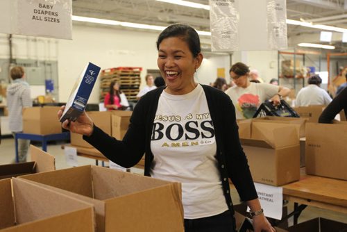 Rina Salazar helps sort food items that are being packaged up for Thanksgiving hampers at Winnipeg Harvest Saturday afternoon.  Her family of four, husband and two sons, immigrated to Canada in June as landed immigrants and wanted to give back to the community that has helped them settle into a new country they now call home. See Carol Sanders story. Oct 10, 2015 Ruth Bonneville / Winnipeg Free Press