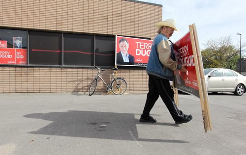 Jim Swettenham, a volunteer for Terry Duguid's campaign, Liberal  candidate for Wpg. South, carries signs out to his vehicle from the headquarters on Pembina Hwy. Saturday. Oct 10, 2015 Ruth Bonneville / Winnipeg Free Press