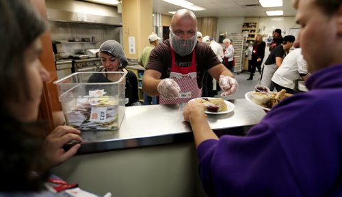 Jake Harder, right, serves food while his niece, Serena, looks on, during Thanksgiving at Siloam Mission, Monday, October 12, 2015. (TREVOR HAGAN/WINNIPEG FREE PRESS) for carol sanders story