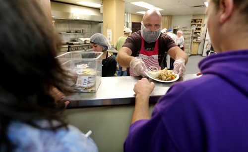Jake Harder, right, serves food while his niece, Serena, looks on, during Thanksgiving at Siloam Mission, Monday, October 12, 2015. (TREVOR HAGAN/WINNIPEG FREE PRESS) for carol sanders story
