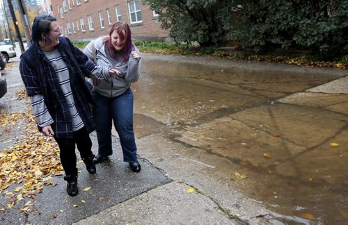 Erika Brown and Jessica Zawadowski laugh after walking through a deep puddle on Assiniboine Avenue, Monday, October 12, 2015. (TREVOR HAGAN/WINNIPEG FREE PRESS) for carol sanders story