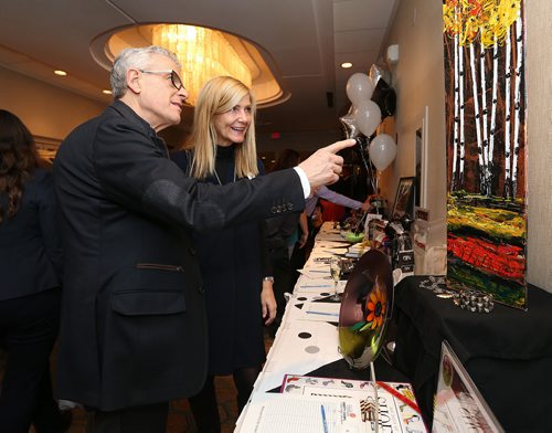 (L-R) Canadian Footwear's Brian Scharfstein (a Winnipeg Harvest board member) and wife Pamela Cipryk check out auction items. Photo by Jason Halstead/Winnipeg Free Press RE: Social page