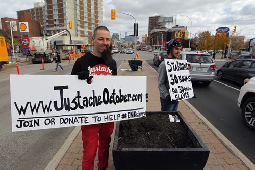 A small group of Justache October participants and supporters will be taking their anti-slavery message to the streets of Winnipeg this weekend on the 2nd annual 30 Hour Standoff. Jason Friesen and his cousin Stephan Friesen stand at Portage Ave. and Maryland spreading their message.  BORIS MINKEVICH / WINNIPEG FREE PRESS  OCT 16, 2015