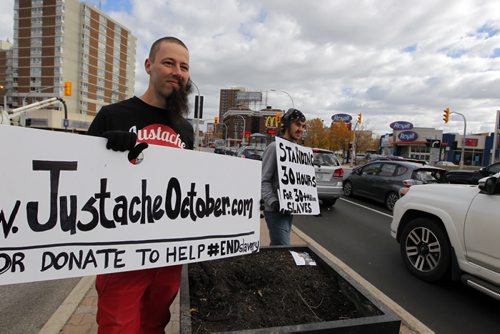 A small group of Justache October participants and supporters will be taking their anti-slavery message to the streets of Winnipeg this weekend on the 2nd annual 30 Hour Standoff. Jason Friesen and his cousin Stephan Friesen stand at Portage Ave. and Maryland spreading their message.  BORIS MINKEVICH / WINNIPEG FREE PRESS  OCT 16, 2015