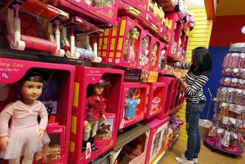 MASTERMIND TOYS - New store opening this month on the NE side of Kenaston and McGillivray.  Store employee Charina Academia tidies up the Our Generation doll section. BORIS MINKEVICH / WINNIPEG FREE PRESS  OCT 16, 2015
