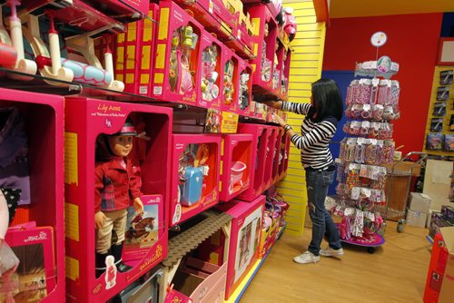 MASTERMIND TOYS - New store opening this month on the NE side of Kenaston and McGillivray.  Store employee Charina Academia tidies up the Our Generation doll section. BORIS MINKEVICH / WINNIPEG FREE PRESS  OCT 16, 2015