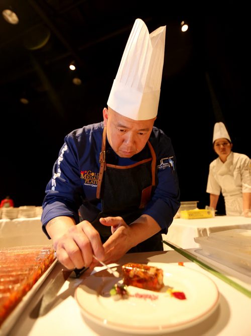 Chef Edward Lam, from Yujiro, plating his dish, foie gras lobster terrine, Gold Medal Plates competition at the Convention Centre, Friday, October 16, 2015. (TREVOR HAGAN/WINNIPEG FREE PRESS)