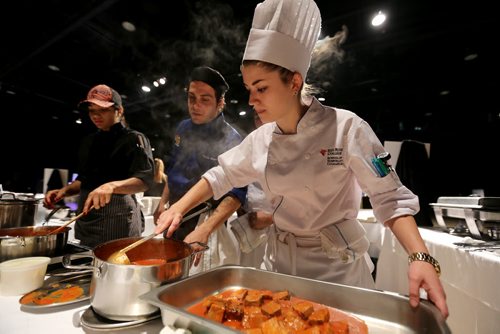 Anna MaDonald stirring stracotto as Chef Fabrizio Rossi, from Nicolinos, looks on, during the Gold Medal Plates competition at the Convention Centre, Friday, October 16, 2015. (TREVOR HAGAN/WINNIPEG FREE PRESS)