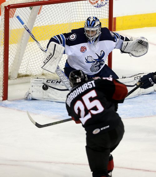 Lake Erie Monsters' Alex Broadhurst (25) fires a shot on Manitoba Moose goaltender Eric Comrie (1) during first period AHL hockey action at MTS Centre, Saturday, October 24, 2015. (TREVOR HAGAN/WINNIPEG FREE PRESS)