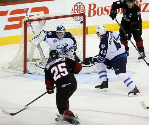 Lake Erie Monsters' Alex Broadhurst (25) hits the post behind Manitoba Moose goaltender Eric Comrie (1) during first period AHL hockey action at MTS Centre, Saturday, October 24, 2015. (TREVOR HAGAN/WINNIPEG FREE PRESS)