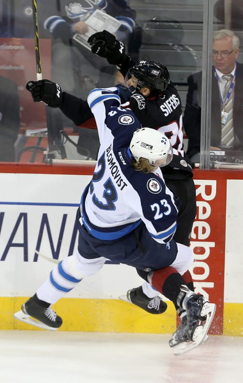 Manitoba Moose Axel Blomqvist (23) gets the worst of a collision with Lake Erie Monsters' Jaime Sifers (26) during first period AHL hockey action at MTS Centre, Saturday, October 24, 2015. (TREVOR HAGAN/WINNIPEG FREE PRESS)