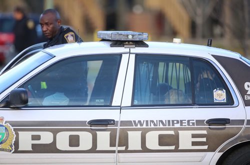 A woman and children sit in the back of a Winnipeg Police cruiser on Keenlyside Street at a standoff, Sunday, October 25, 2015. (TREVOR HAGAN / WINNIPEG FREE PRESS)