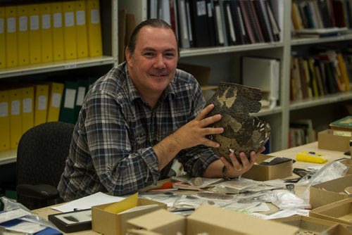 Kevin Brownlee, curator of archeology at Manitoba Museum, examines an artifact on one of the lab tables. 150922 - Wednesday, September 23, 2015 -  MIKE DEAL / WINNIPEG FREE PRESS