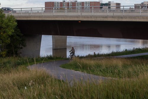 A cyclist rides on the Bishop Grandin Greenway as the Red River flows underneath the spans of the Bishop Grandin bridge. 150923 - Wednesday, September 23, 2015 -  MIKE DEAL / WINNIPEG FREE PRESS
