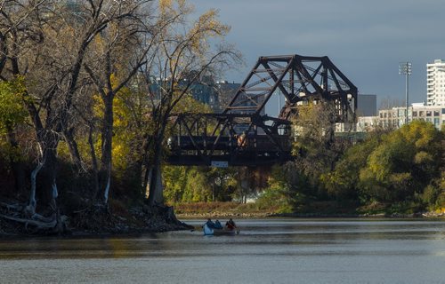 A large canoe makes its way along the Red River just north of the Waterfront Drive rail bridge. 151006 - Tuesday, October 06, 2015 -  MIKE DEAL / WINNIPEG FREE PRESS