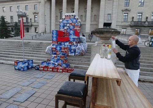 Hotel owner Angelo Mondragon set up a bar after he assembled his throne of beer cases in front of the Manitoba Legislative Bld. Monday morning to protest the province's role in the decline of rural hotels.  October 26, 2015 (Wayne Glowacki/Winnipeg Free Press)