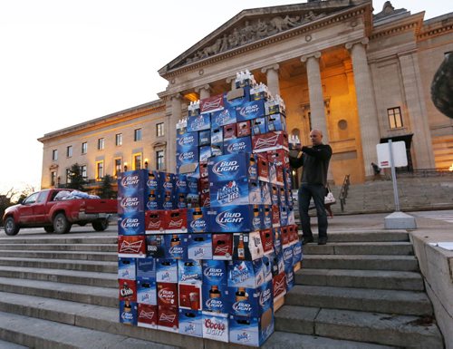 Angelo Mondragon, president of the Rural Hotel Owners of Manitoba assembles a throne of beer cases in front of the Manitoba Legislative Bld. Monday morning to protest the province's role in the decline of rural hotels.Bill Redekop  story. Wayne Glowacki / Winnipeg Free Press October 26 2015