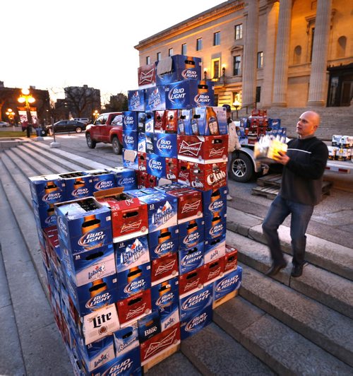 Angelo Mondragon, president of the Rural Hotel Owners of Manitoba assembles a throne of beer cases in front of the Manitoba Legislative Bld. Monday morning to protest the province's role in the decline of rural hotels.Bill Redekop  story. Wayne Glowacki / Winnipeg Free Press October 26 2015