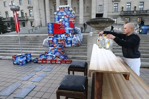 Angelo Mondragon, president of the Rural Hotel Owners of Manitoba sets up a bar after assembling a throne out of beer cases in front of the Manitoba Legislative Bld. Monday morning to protest the province's role in the decline of rural hotels.Bill Redekop  story. Wayne Glowacki / Winnipeg Free Press October 26 2015