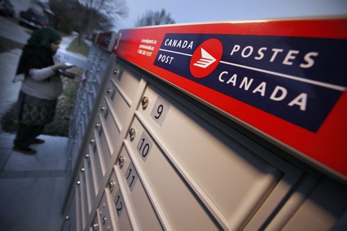 October 26, 2015 - 151026  -  A woman collects mail at a community mailbox Monday, October 26, 2015. Canada Post has suspended installation of these mailboxes until it hears from Canada's new federal government. John Woods / Winnipeg Free Press