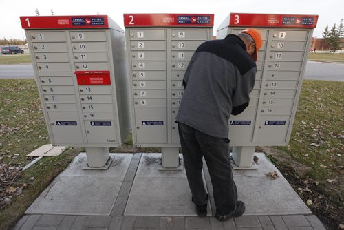 October 26, 2015 - 151026  - Nelson Tan collects mail at a community mailbox Monday, October 26, 2015. Canada Post has suspended installation of these mailboxes until it hears from Canada's new federal government. John Woods / Winnipeg Free Press