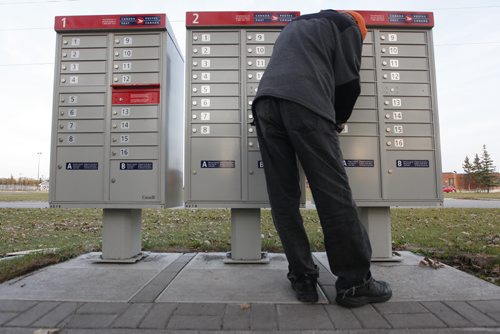 October 26, 2015 - 151026  - Nelson Tan collects mail at a community mailbox Monday, October 26, 2015. Canada Post has suspended installation of these mailboxes until it hears from Canada's new federal government. John Woods / Winnipeg Free Press