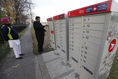 October 26, 2015 - 151026  - Kurnail Singh (L) and Gurcharan Singh  collect mail at a community mailbox Monday, October 26, 2015. Canada Post has suspended installation of these mailboxes until it hears from Canada's new federal government. John Woods / Winnipeg Free Press