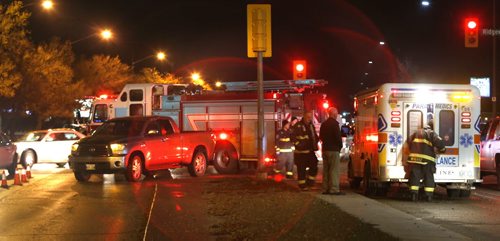 Winnipeg Fire Paramedics on the scene on Main St. at Ridgecrest Ave. after a pedestrian was struck by a vehicle as a light rain falls Wednesday morning. Wayne Glowacki / Winnipeg Free Press October 28 2015