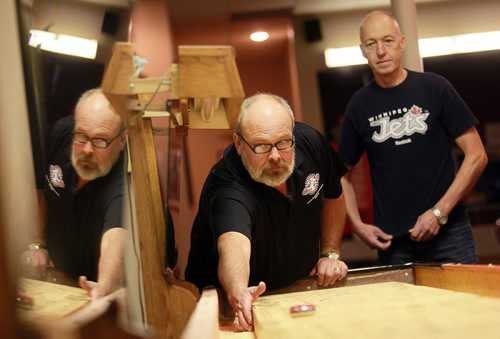 Mike Collins takes aim down the shuffleboard as Mike Jacoby watches at the John Osborne ANAF Legion Wednesday night. The shuffleboarders at the legion hosted the National Championships three weeks ago. See Dave Sanderson's story.  October 28, 2015 - (Phil Hossack / Winnipeg Free Press)