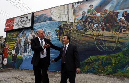 At left, Tom Ethans, Executive Director of Take Pride Winnipeg with Tam Nguyen by the mural depicting the journey of Tam's and other Vietnamese refugees that eventually ended in Winnipeg. In 1980, Nguyen came to Canada as a refugee from Vietnam with no money, no understanding of English and no education.  Today, he owns three buildings and three businesses. The mural by  Sarah J. Collard commissioned by Take Pride Winnipeg on the side of Joy's Convenience Store at 248 River Ave., a building Tam owns was officially unveiled Thursday morning.   Wayne Glowacki / Winnipeg Free Press October 29  2015