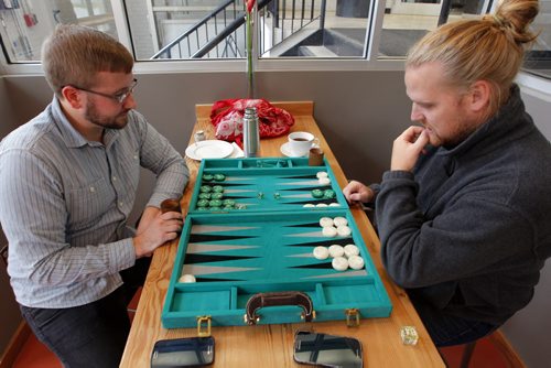 Winnipeg Symphony Orchestra bass players (left to right) Daniel Perry and Andrew Goodlett enjoy a quick game of backgammon during their lunch break today at joe and lily, a coffee house near the Centennial Concert Hall. The WSO is rehearsing charts for Mahler Fest. BORIS MINKEVICH / WINNIPEG FREE PRESS  OCT 29, 2015