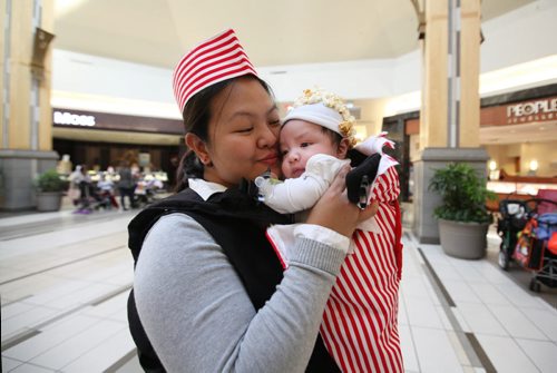Aileen Linsingan holds her 2 month old son, Brayden in her arms dressed who is dressed as a bag of popcorn with her as the vendor, a costume she made after seeing it on Pinterest, while at Kildonan Place mall with her kids Friday afternoon for their annual Trick or treating at the mall event.   Standup photo Oct 29, 2015 Ruth Bonneville / Winnipeg Free Press