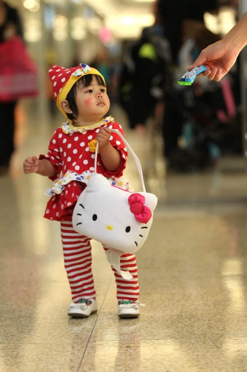 14 -month-old Julienne Gloria stares at the cant that one of the vendors is about to put into her sack while trick or treating with her family at  Kildonan Place Mall Friday afternoon for their annual Halloween event.   Standup photo Oct 29, 2015 Ruth Bonneville / Winnipeg Free Press